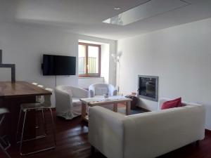 un soggiorno con mobili bianchi e TV di Appartement "Luigi Loft" a Intragna (Centovalli)