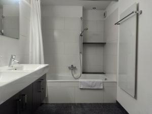 um banheiro branco com uma pia e um chuveiro em Appartement "Luigi Loft" em Intragna