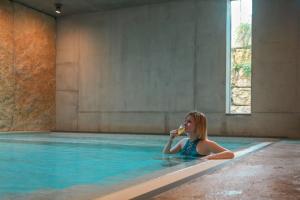 una ragazza in piscina che mangia cibo di Röschenzerhof a Röschenz