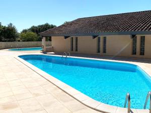 a swimming pool in front of a house at Domaine des Barons de la Chasse -- Eco-Domaine -- Lodge in Bouquet