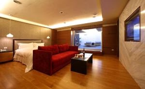 a living room with a bed and a red couch at Elan-Motel in Wujie