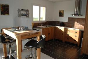 a kitchen with a wooden table and bar stools at Gite Labradors De Bailly - Giverny in Saint-Pierre-la-Garenne