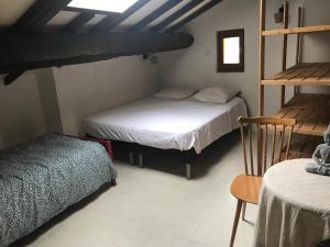 a room with two bunk beds and a chair at Gîte à la ferme La Bedigue in Lambert