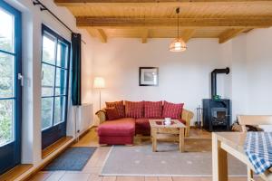 a living room with a red couch and a table at Am Achterwasser DORF 12 in Rankwitz
