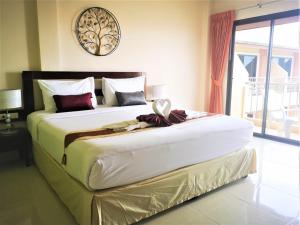 a large bed in a bedroom with a large window at Seven Seas Hotel in Patong Beach