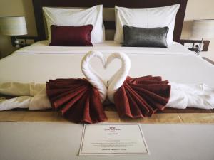 two swans making a heart sign on a bed at Seven Seas Hotel in Patong Beach