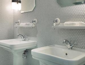 - une salle de bains blanche avec deux lavabos et un miroir dans l'établissement Hotel Bachaumont, à Paris