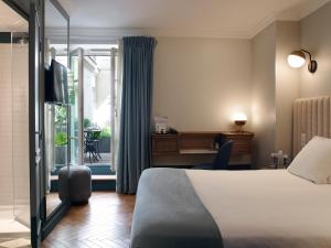 a bedroom with a bed and a window at Hotel Bachaumont in Paris