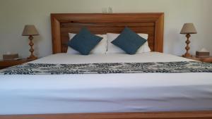 a bedroom with a bed with blue pillows at Villa Belle Plage in Anse Kerlan
