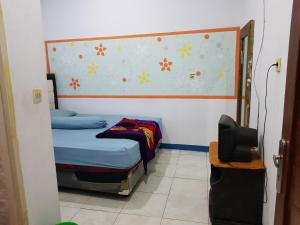 a small bedroom with a bed and a tv at Hotel Alifah 2 in Tangerang