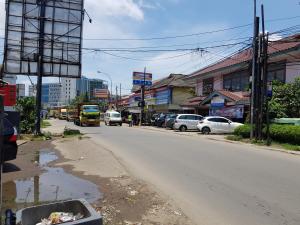 een straat met auto's aan de kant van de weg bij Hotel Alifah 2 in Tangerang