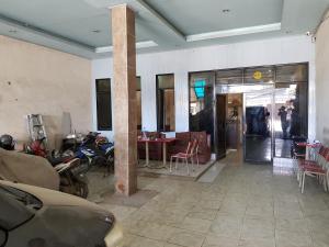 Zimmer mit Motorrad, Tisch und Stühlen in der Unterkunft Hotel Alifah 2 in Tangerang