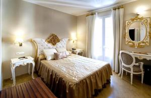 a bedroom with a large bed and a mirror at Adriano Boutique Sevilla in Seville