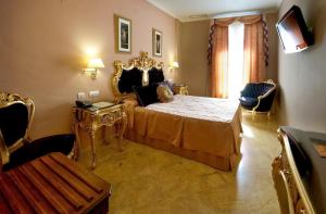 塞維利亞的住宿－塞維利亞阿德里亞諾精品酒店，一间卧室配有一张特大号床和金色家具