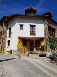 a large white and yellow house on a street at Mirador de Enterrias in Enterria