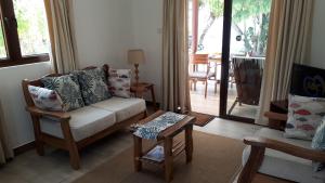 uma sala de estar com um sofá e uma mesa em Villa Belle Plage em Anse Kerlan