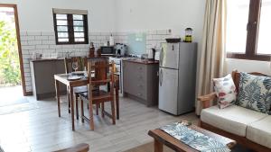 cocina y sala de estar con nevera y mesa en Villa Belle Plage en Anse Kerlan