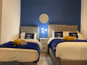 - une chambre avec 2 lits et un mur bleu dans l'établissement HLA Holytown, à Mossend
