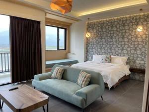 a bedroom with a bed and a couch at 蘴旅民宿 in Chishang