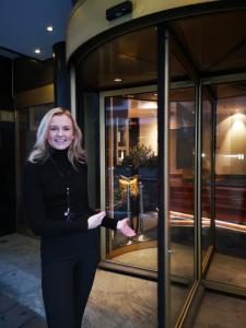 Eine Frau, die vor einem Glasfenster steht. in der Unterkunft First Hotel Millennium in Oslo