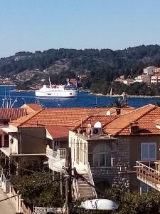 a boat in the water with houses and a city at Rooms & Apartments Mirakul in Vela Luka
