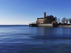 a large body of water with a building in the background at Ferienwohnung Magnolie in Langenargen in Langenargen +29 photos