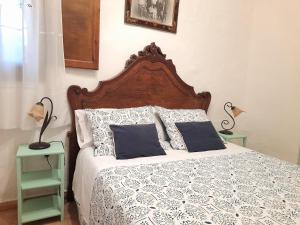 1 cama con cabecero de madera y almohadas en Apartamentos Rurales Fuente de Marzo, en Anna 28 fotos más