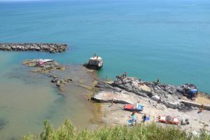 un grupo de personas de pie sobre una roca en el agua en Cuore di Vieste en Vieste