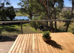 a wooden table with a potted plant on a porch at Peppertree Hill in Mudgee