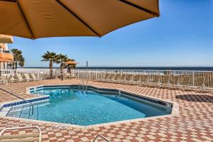 a swimming pool with an umbrella and the beach at Enclave 605 in Orange Beach