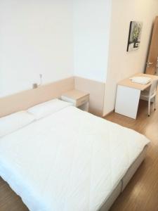 a white bedroom with a white bed and a desk at Residence Delta in Rovigo