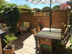 a wooden deck with a table and an umbrella at Résidence Village Marin Catalan TORREILLES PLAGE in Torreilles