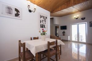 a dining room with a white table and chairs at Apartments Vukicevic in Šibenik