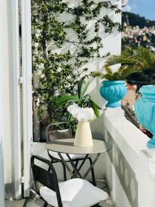 einen Tisch und Stühle auf einem Balkon mit Pflanzen in der Unterkunft Les Lilas in Roquebrune-Cap-Martin