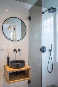 La salle de bains est pourvue d'un lavabo et d'une douche. dans l'établissement Studios at the canal, à Amsterdam