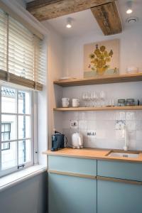 une cuisine avec un comptoir et une fenêtre dans l'établissement Studios at the canal, à Amsterdam 2 autres photos