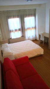 a bedroom with a large bed and a red couch at Residence Delta in Rovigo
