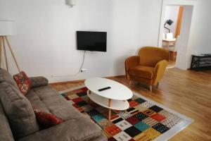 a living room with a couch and a table and a chair at Gästewohnung Helena in Völkermarkt