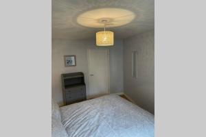 a bedroom with a bed and a chandelier at Idyllic Self Contained Annex Flat in Eaton in Cringleford