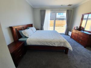 a bedroom with a large bed and a window at Charm Villa in Clyde North