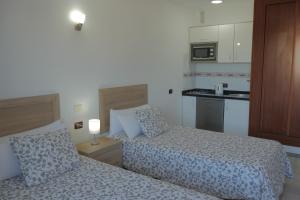 a hotel room with two beds and a kitchen at Apartamentos Pirámides in Playa de las Americas