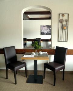 1 mesa y 2 sillas en una habitación con espejo en Parkhotel Kirchberg, en Kirchberg in Tirol