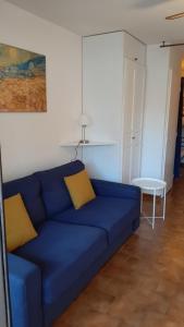 um sofá azul com duas almofadas amarelas numa sala de estar em Comfortable Air Conditioned Studio With Terrace em Bandol