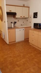 uma cozinha com electrodomésticos brancos e piso em madeira em Comfortable Air Conditioned Studio With Terrace em Bandol