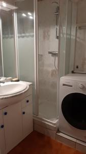 uma casa de banho com um chuveiro, um lavatório e uma máquina de lavar roupa em Comfortable Air Conditioned Studio With Terrace em Bandol