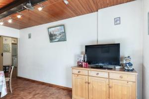 a living room with a television on a wooden cabinet at Appartement accueillant à Saint-Martin-de-Belleville in Saint-Martin-de-Belleville