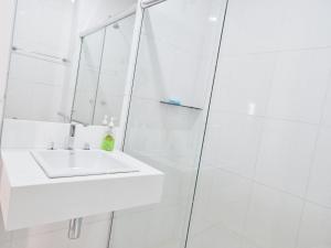 a white bathroom with a sink and a shower at Leblon House I in Rio de Janeiro
