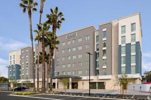 an office building with palm trees in a parking lot at Staybridge Suites - Long Beach Airport by IHG in Long Beach