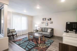 WoodSpring Suites Detroit Madison Heights في ماديسون هايتس: غرفة معيشة مع أريكة وتلفزيون