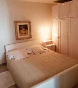 una camera da letto con un grande letto con un'immagine appesa alla parete di Apartment Aduro a Šibenik